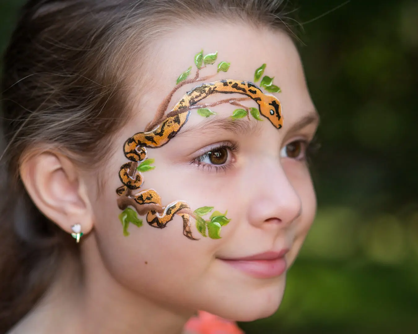 A girl with a snake painted on her face.