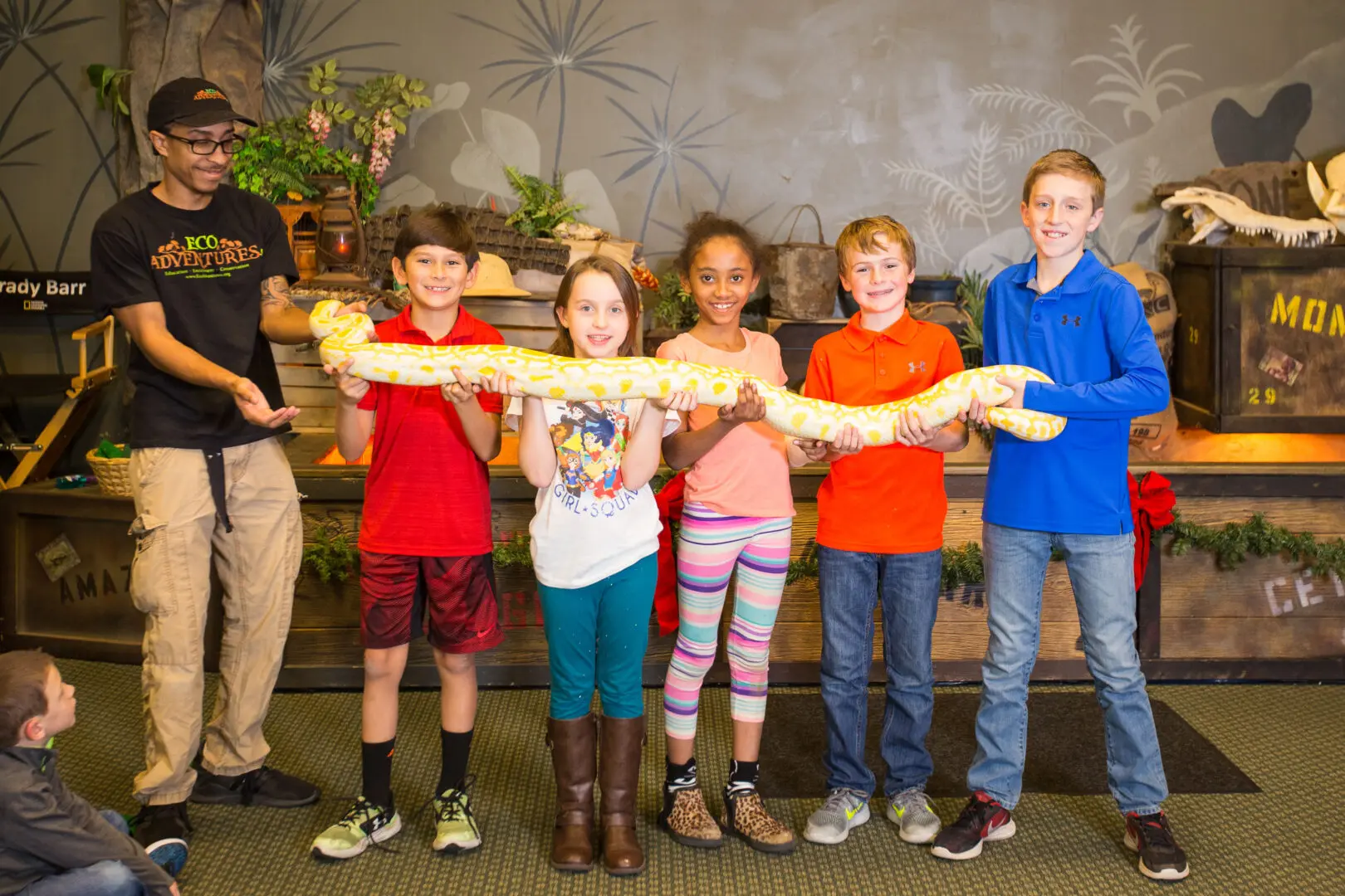 A group of kids holding up a snake.