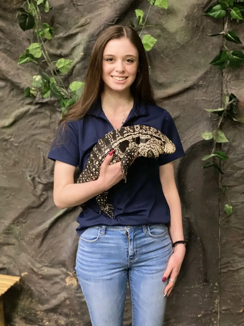 A woman holding an animal in her hand.