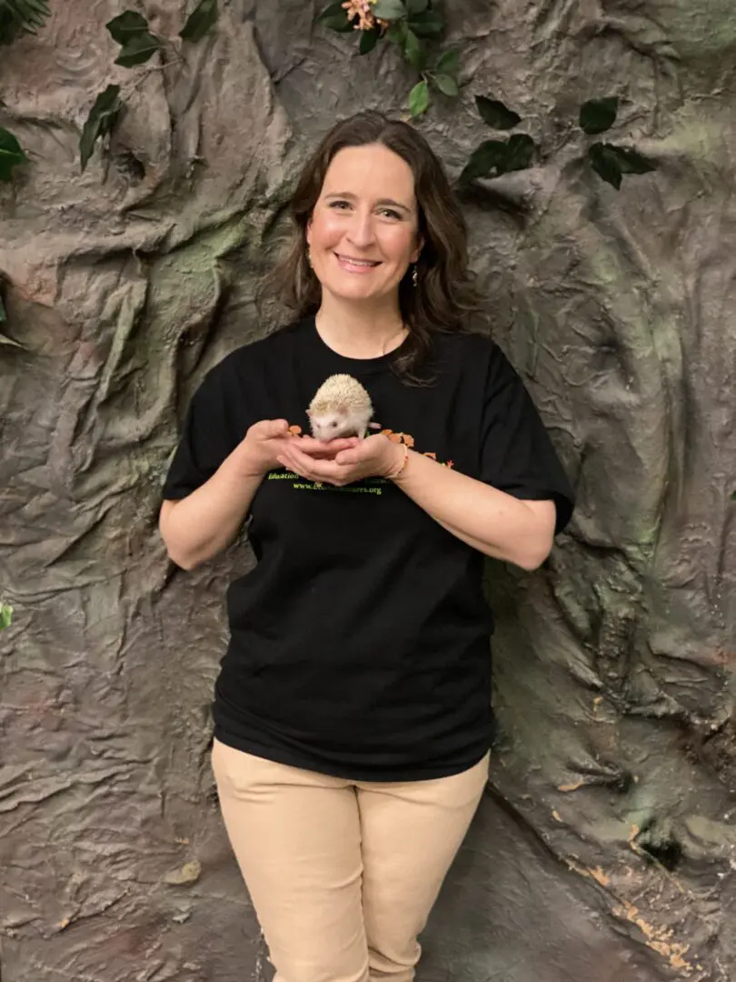 A woman holding an animal in her hands.