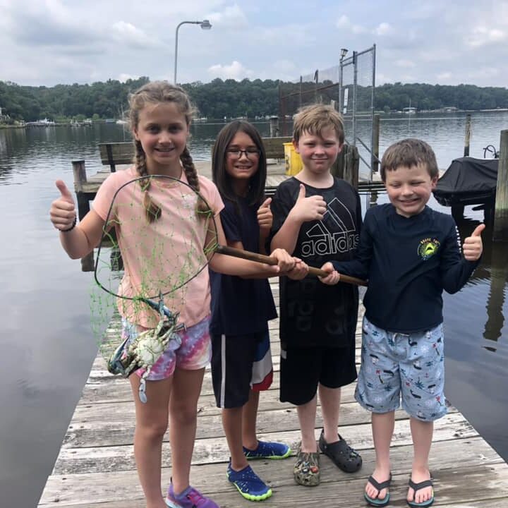A group of kids standing on the dock